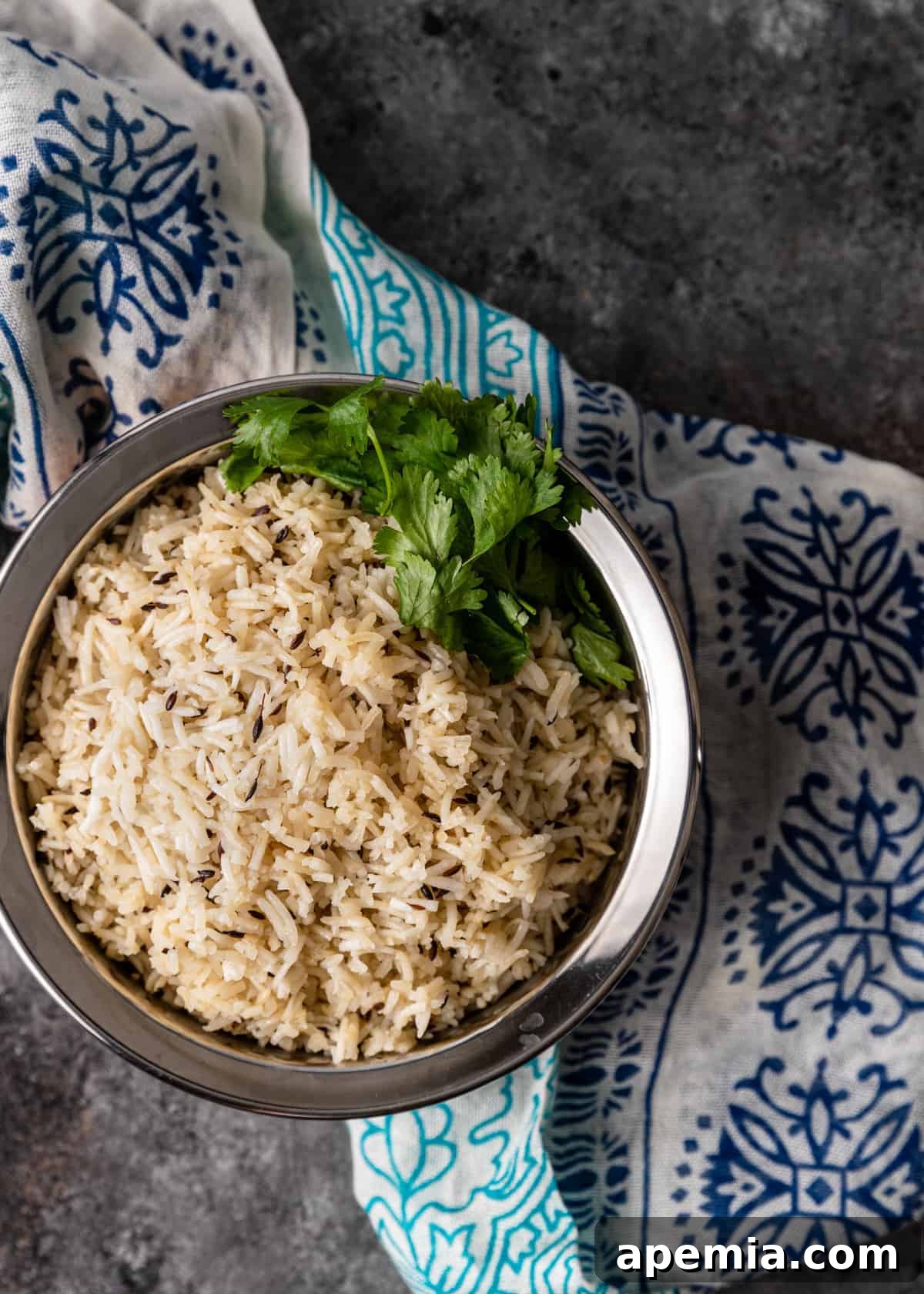 Aromatic Jeera Rice 8 overhead: dish of jeera rice on colorful silk scarf