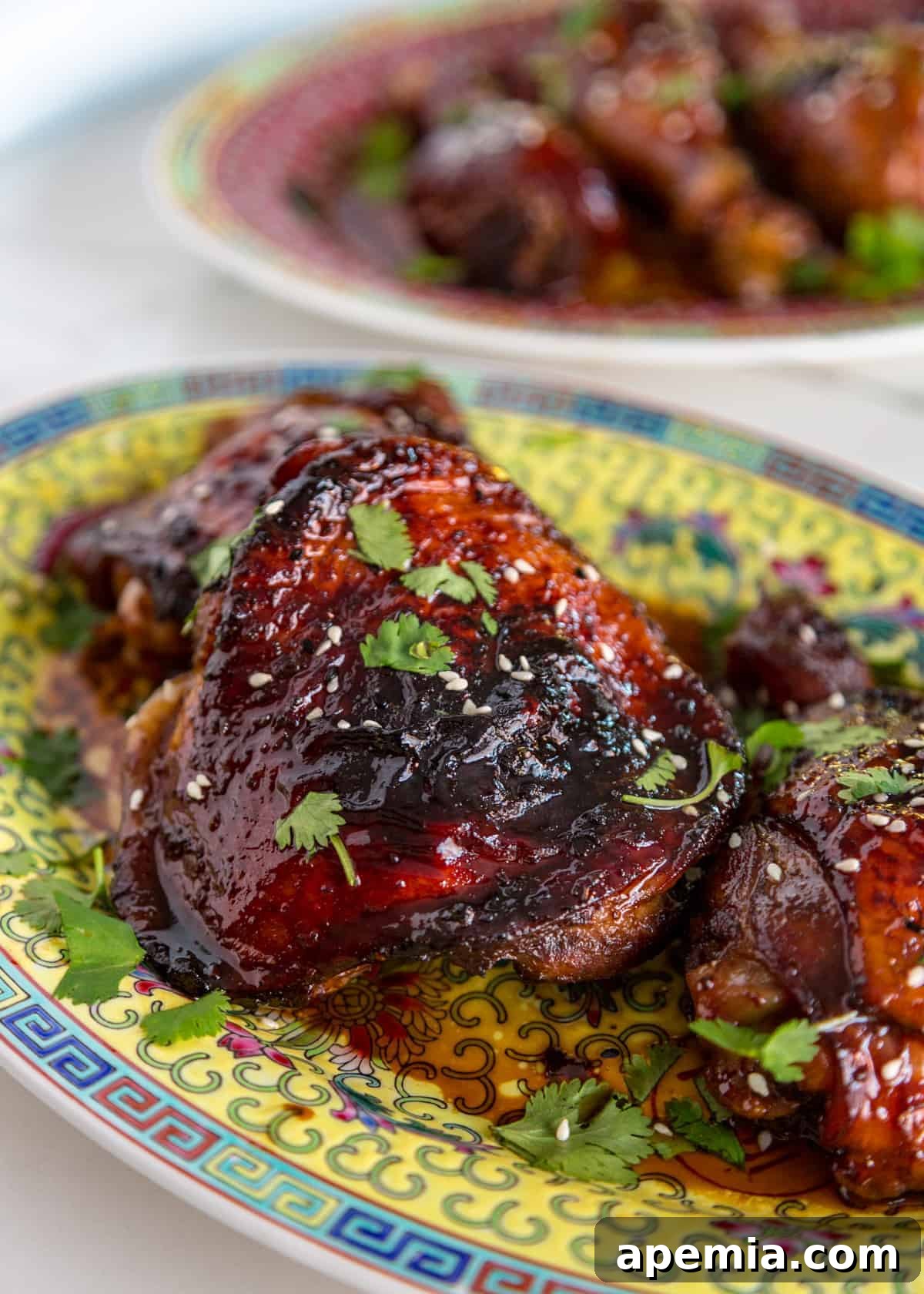 Close-up platter of glistening baked honey sesame chicken, showcasing the sticky glaze
