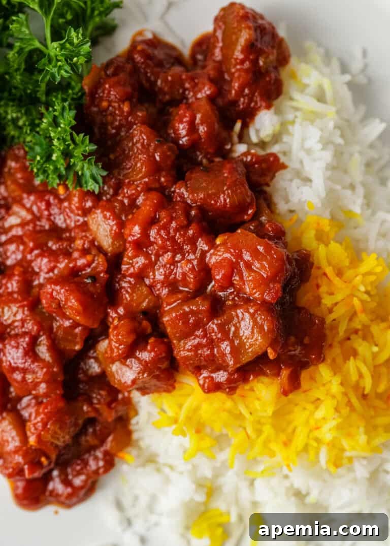 closeup: serving of eggplant stew over steamed white and yellow rice