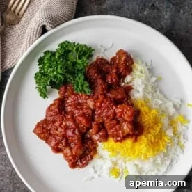overhead: khoresh bademjan on plate with cooked rice