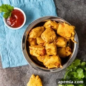 overhead: platter of paneer pakora with red dipping sauce, indicating the final dish