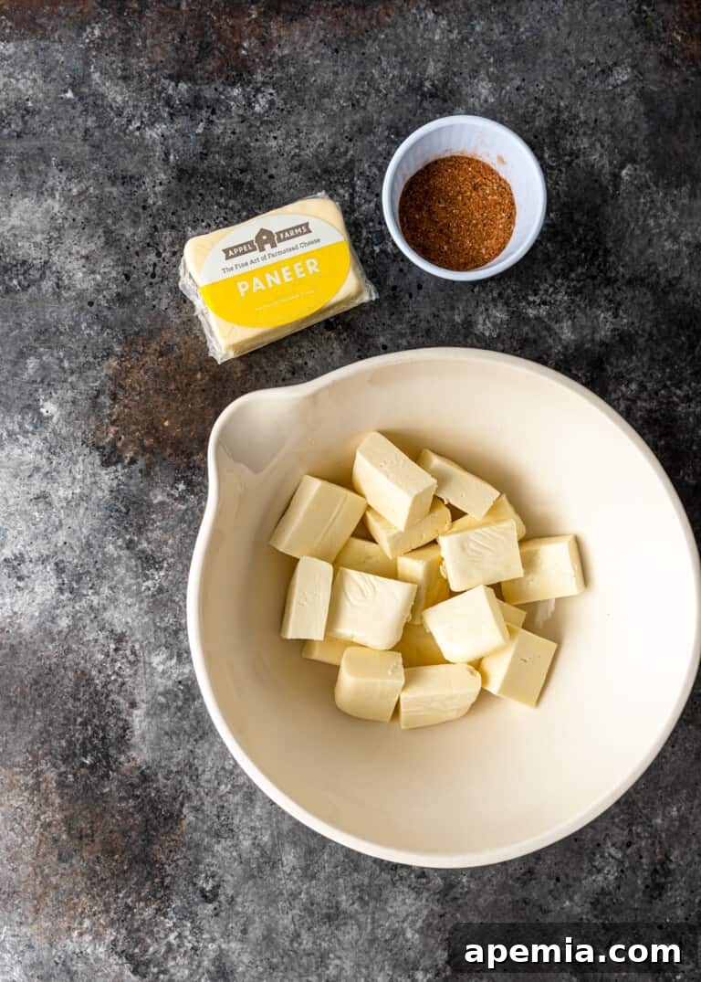 overhead process shot: neatly cubed paneer in a pristine white bowl, ready for seasoning