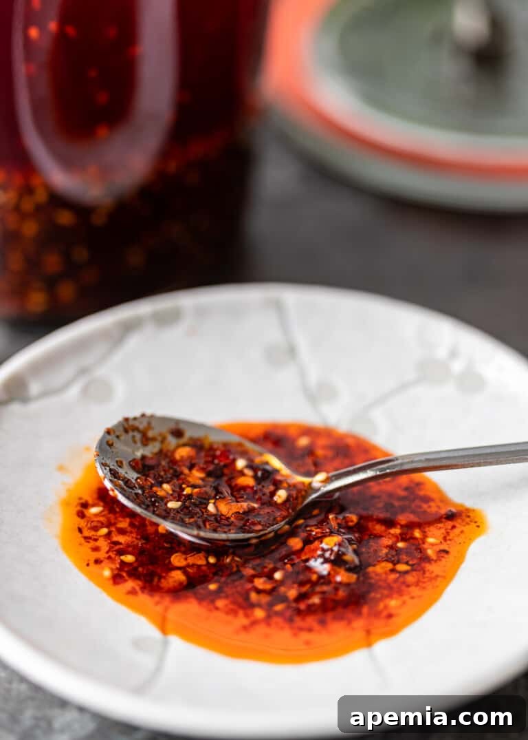 close up of crispy chili oil with spoon on white dish