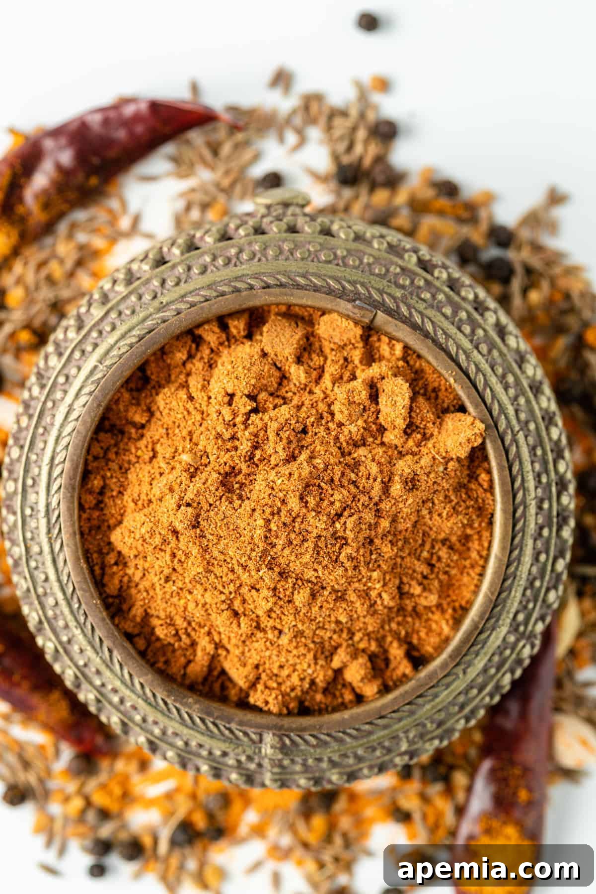 overhead: a small elegant dish filled with vibrant, reddish-brown Ethiopian Berbere spice blend, ready to be used in cooking