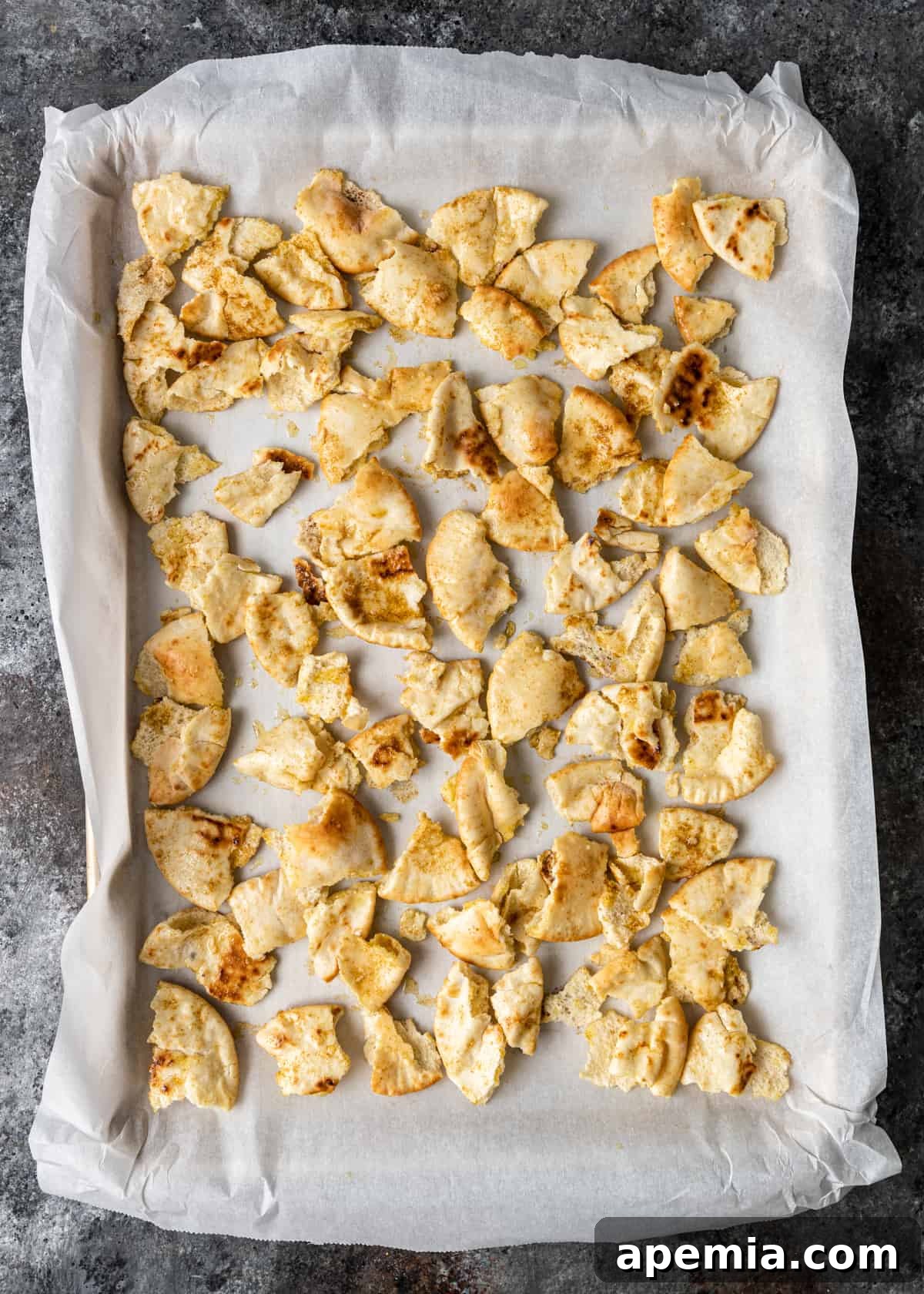 overhead process shot: pieces of pita bread on parchment paper