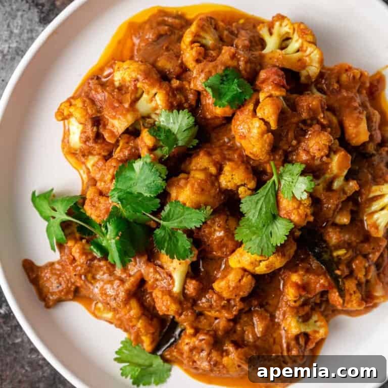 Overhead view of a delicious plate of Gobi Masala cauliflower curry garnished with fresh cilantro.