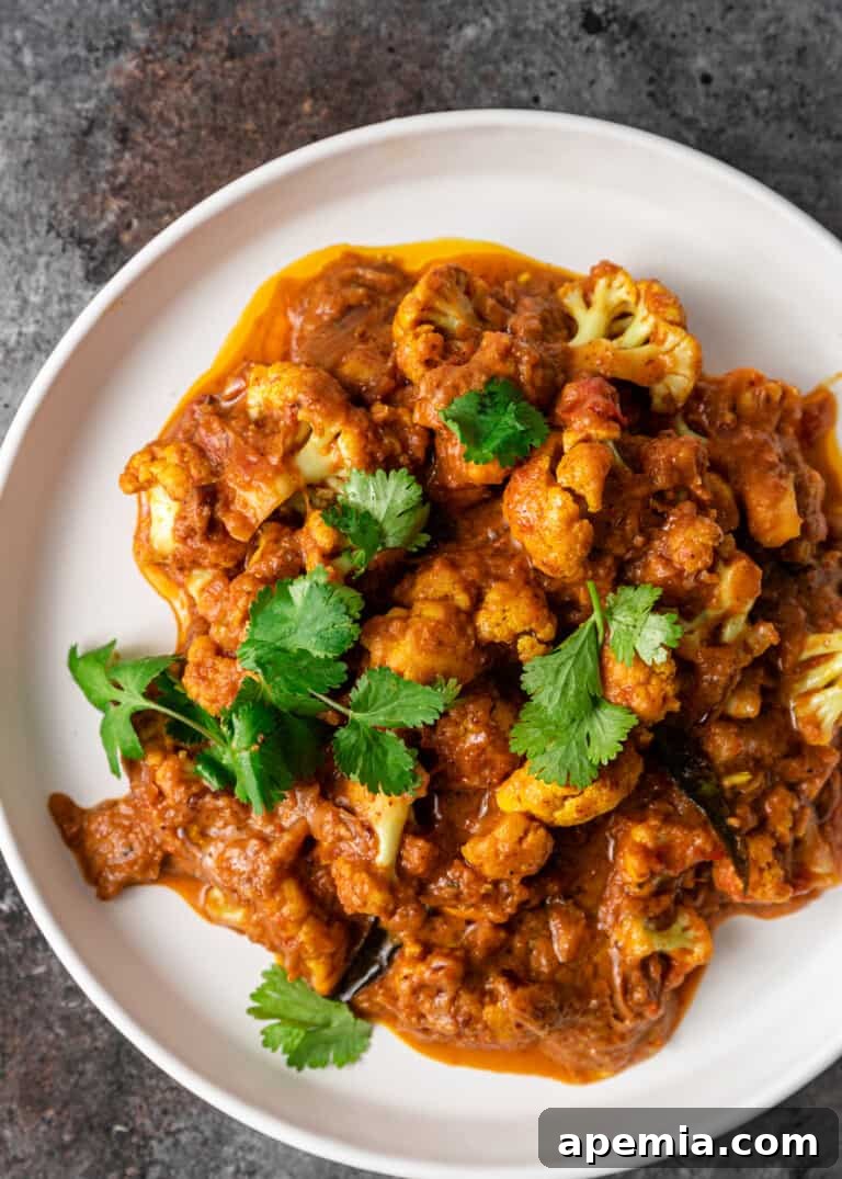 A vibrant bowl of Gobi Masala, a healthy Indian cauliflower curry, garnished with fresh herbs and ready to be served.