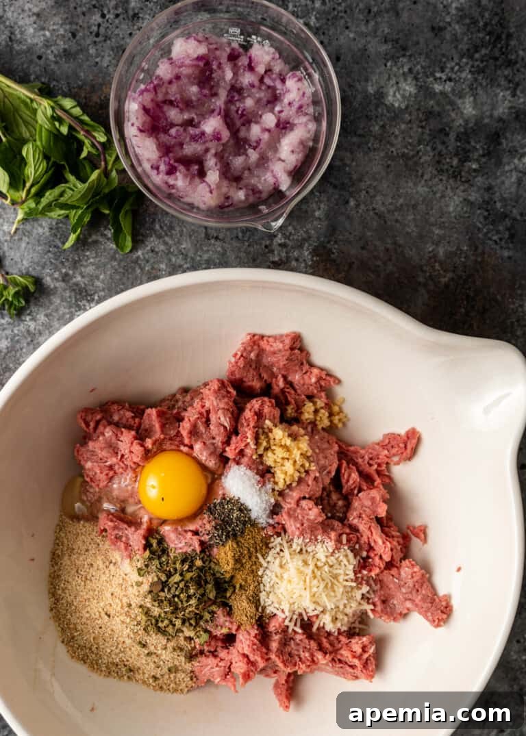 Authentic Pan-Fried Greek Lamb Keftedes 5 overhead: keftedes greek meatball ingredients in a bowl, showcasing fresh herbs and spices