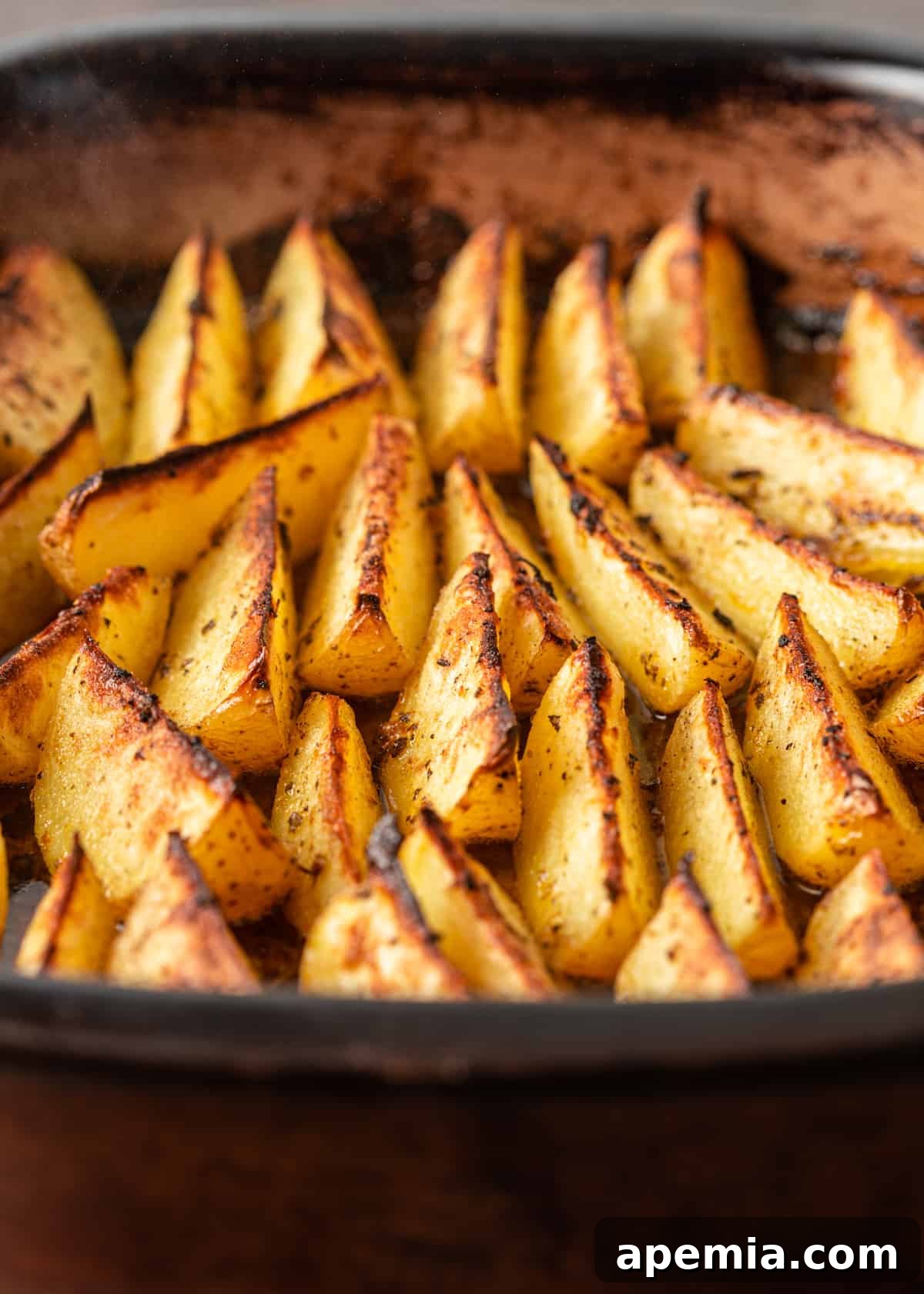 closeup: pan of beautifully roasted greek potatoes, golden and inviting