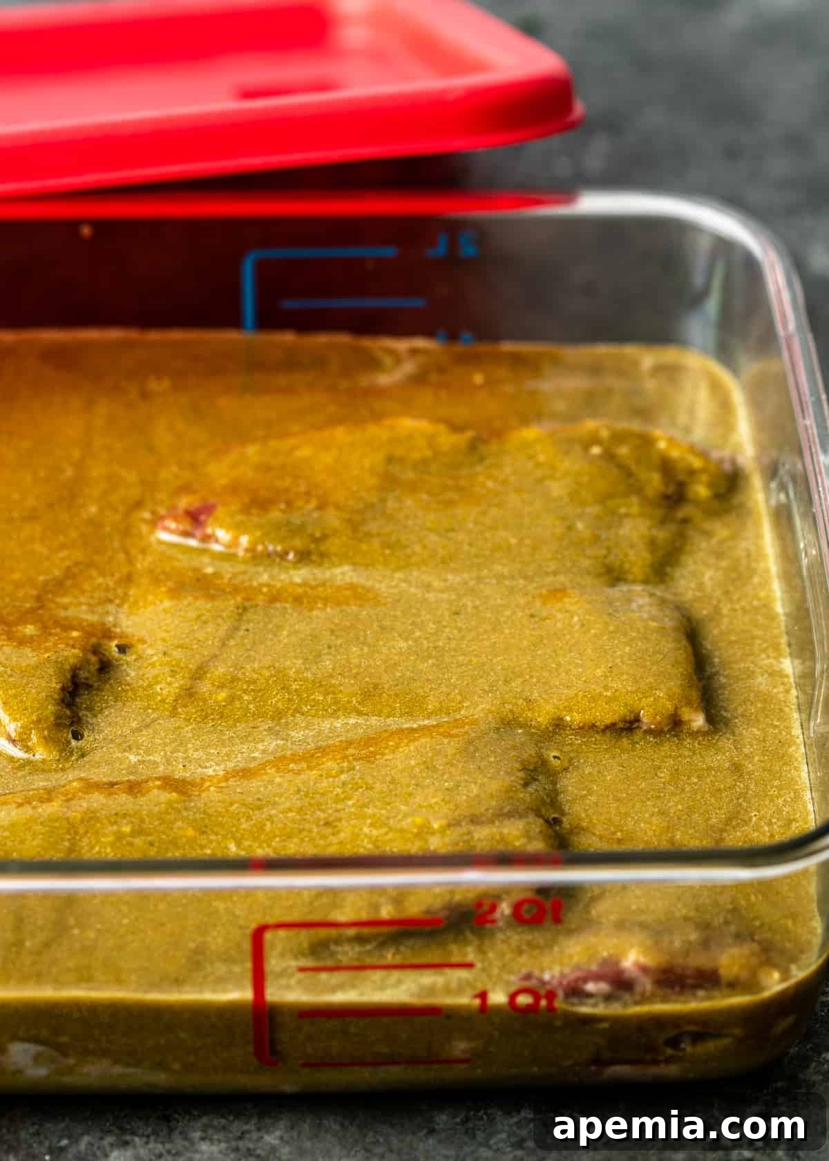 Meat soaking in glass dish of bulgogi marinade