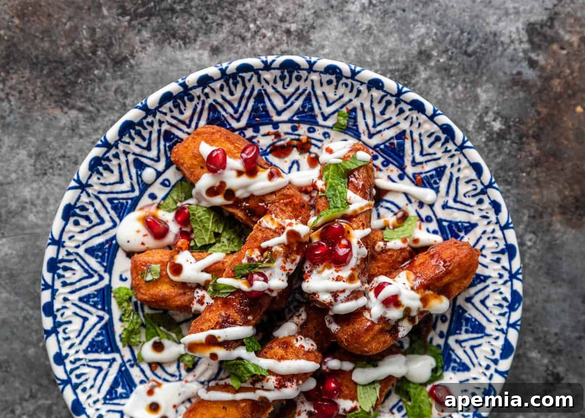 Overhead shot of a plate brimming with golden crispy halloumi fries, garnished beautifully with fresh toppings.