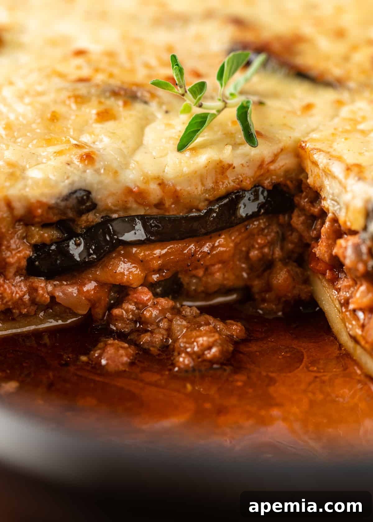 A side view close-up of a moussaka slice, perfectly revealing each distinct layer of eggplant, meat, and béchamel.