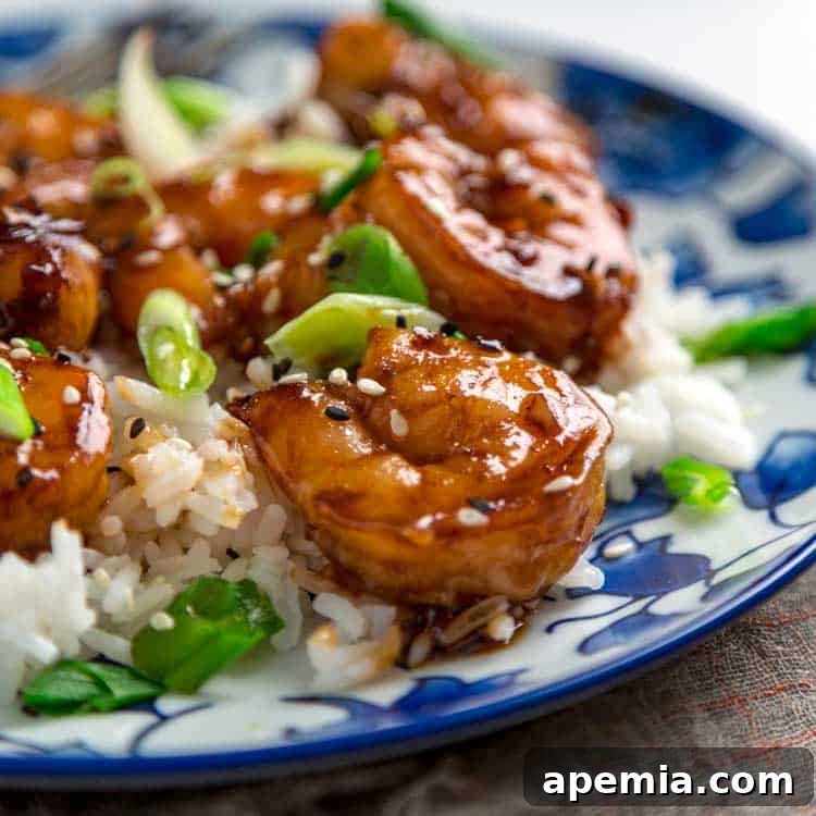 A vibrant plate filled with plump honey garlic shrimp, glistening with a rich, sticky sauce, ready to be enjoyed.