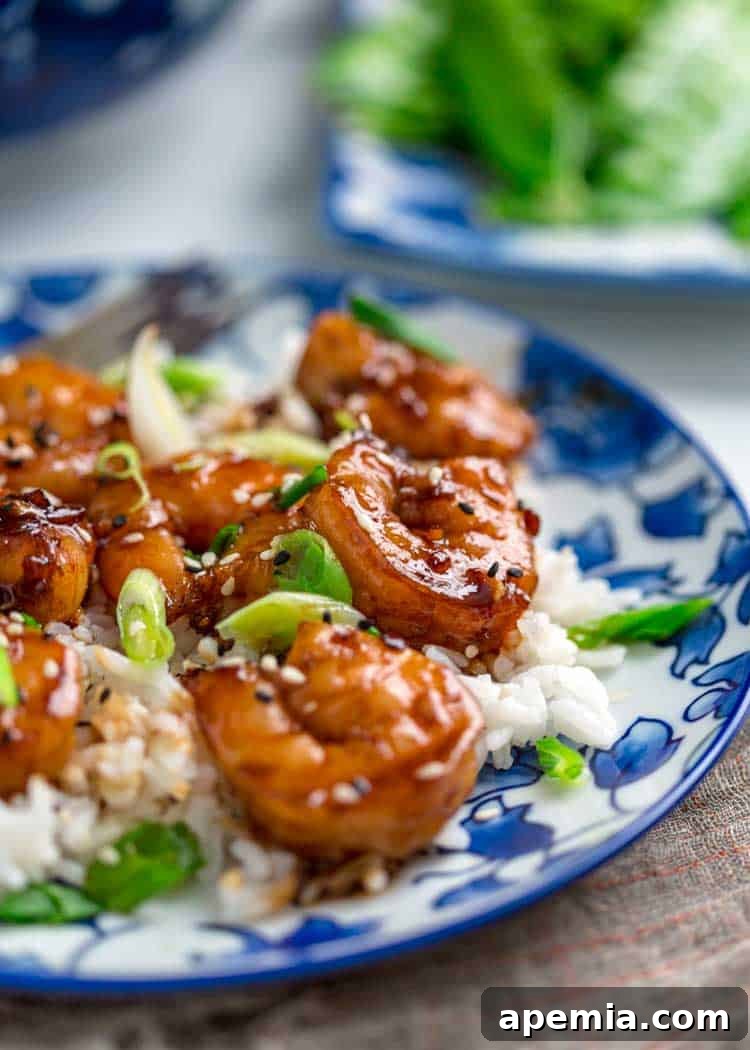 A side view of a serving of plump honey garlic shrimp, showcasing its rich glaze and perfect sear.