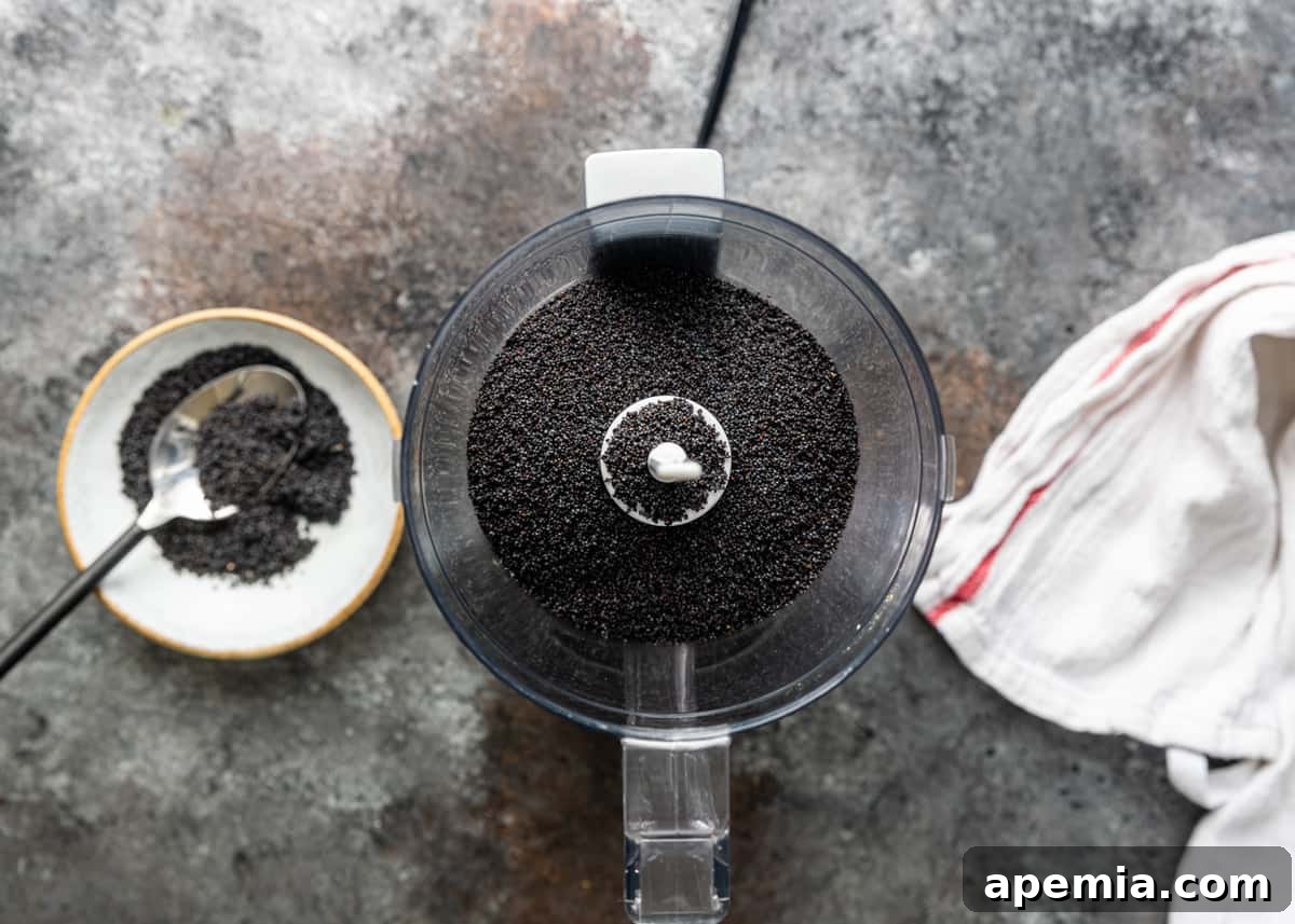 Overhead view of whole poppy seeds being processed in a food processor, ready to be ground.