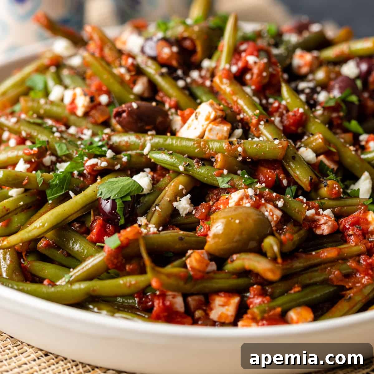 closeup: greek green beans fasolakia in a white serving bowl
