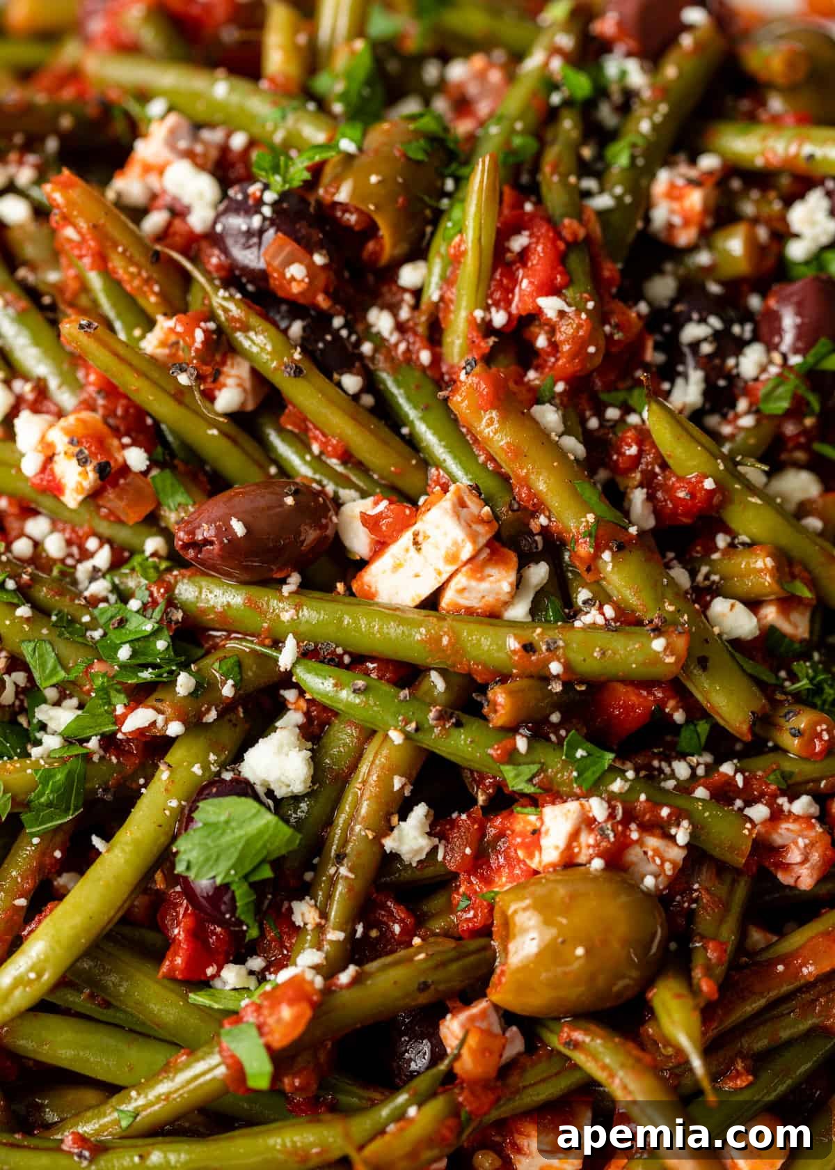 extreme closeup: fasolakia recipe with olives and feta on top 