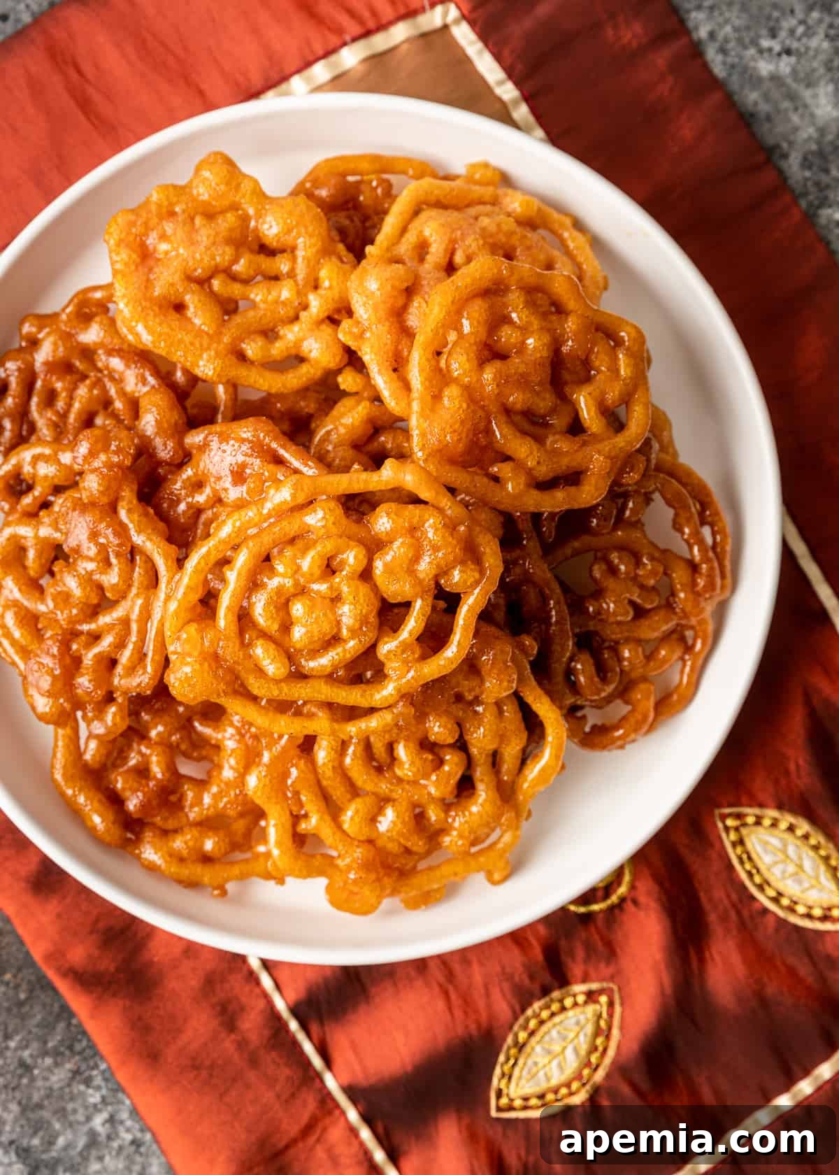 overhead shot of a plate brimming with homemade Indian funnel cake, golden and sweet