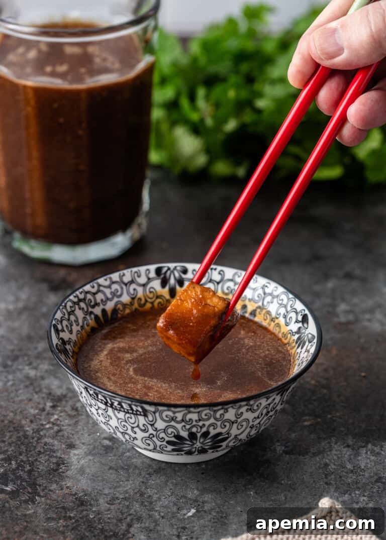 dipping food into ginger sauce with chopsticks