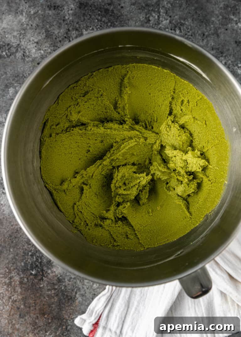 Overhead process shot: vibrant green cookie batter after combining wet and dry ingredients, showcasing the beautiful color of matcha.