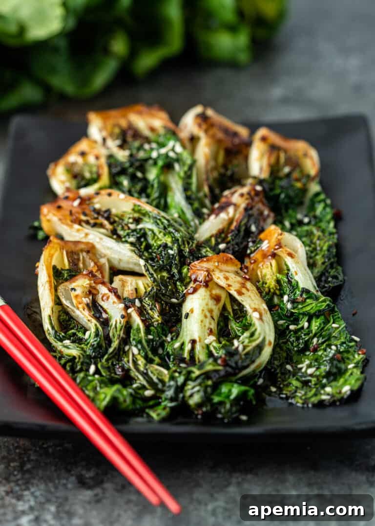 bok choy stir fry on black plate with red chopsticks on side