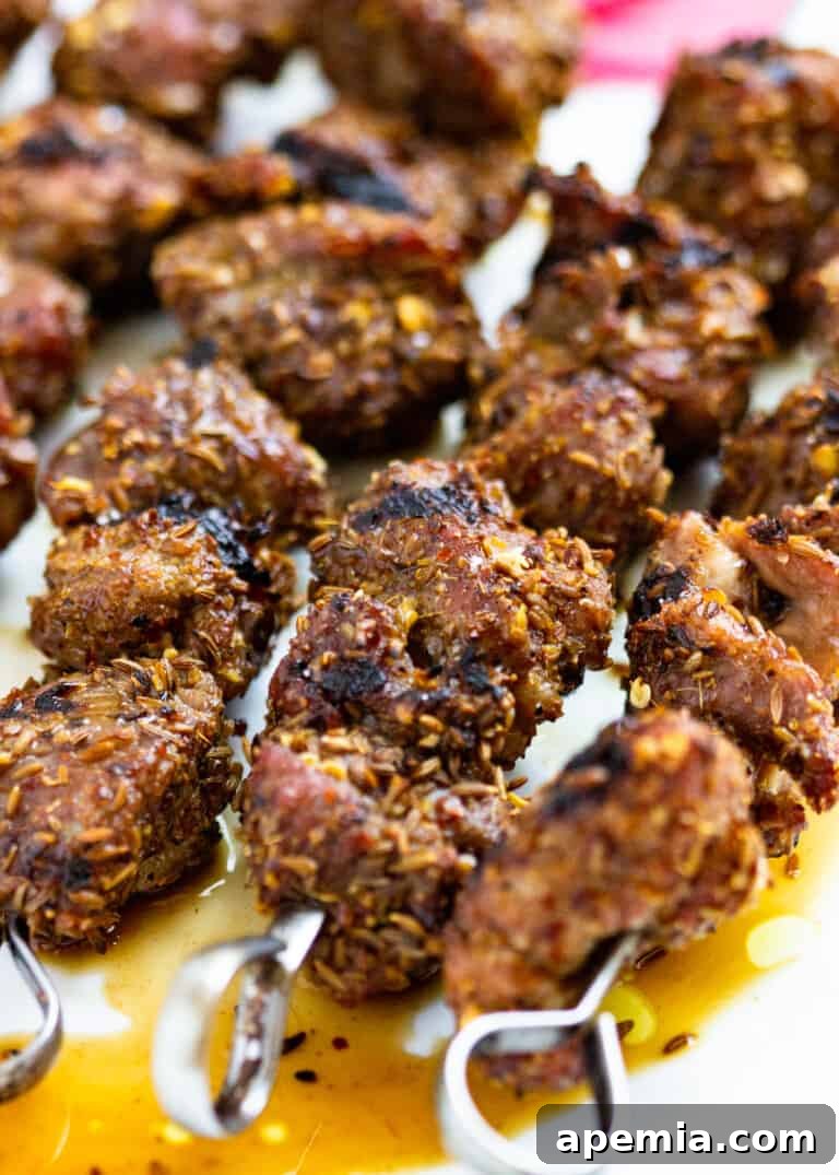 several grilled lamb skewers on a plate