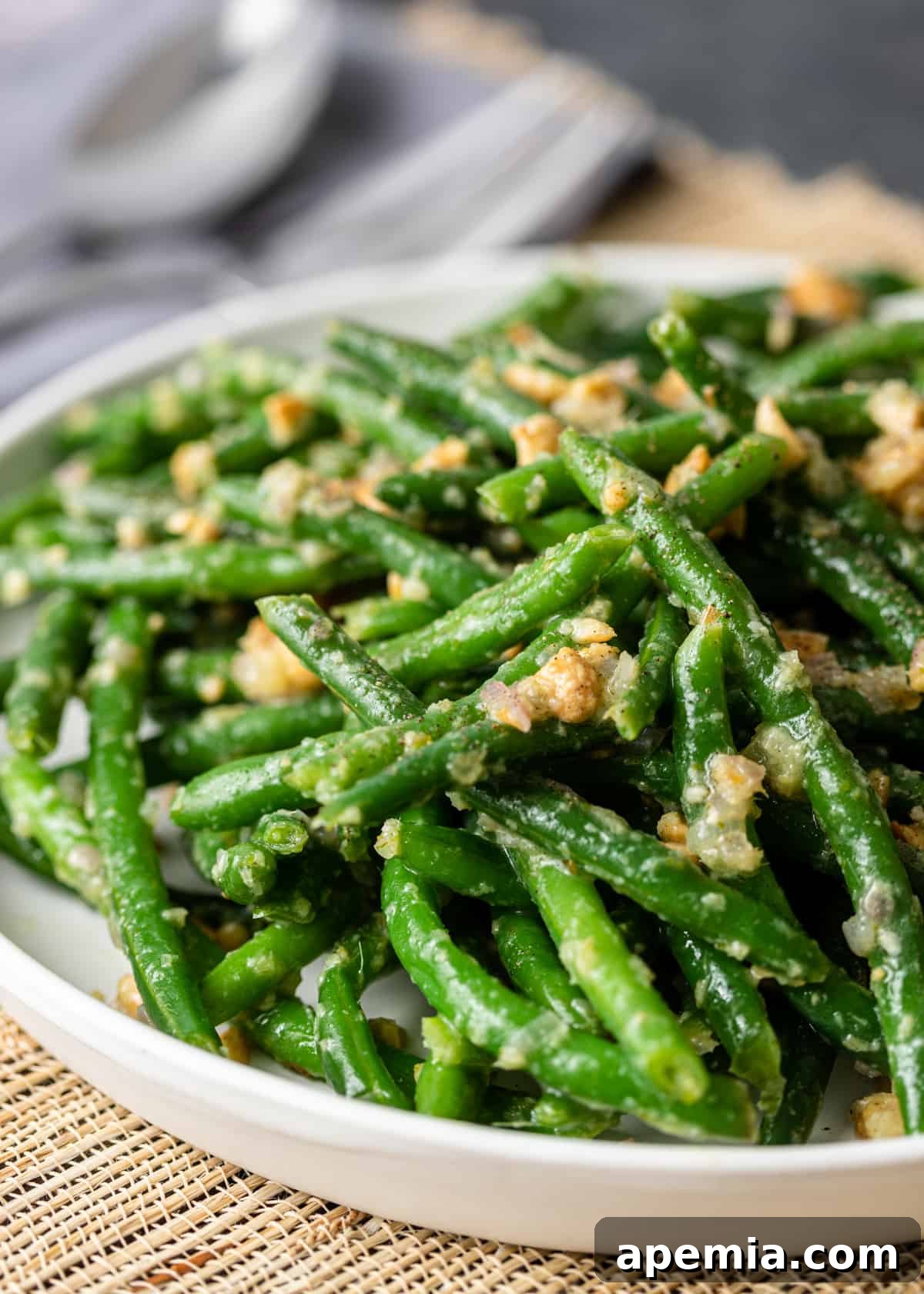 Sesame Garlic Green Beans 9 closeup: Asian green beans garnished with fresh herbs on a white plate