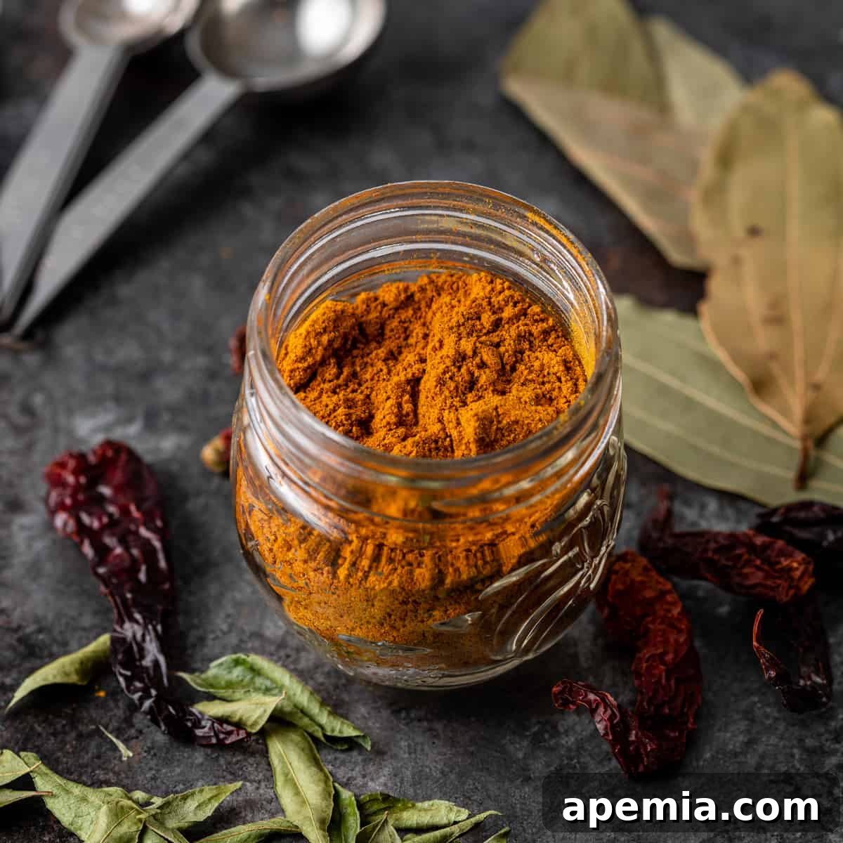 A jar of homemade Madras Curry Powder, ready to be used in authentic Indian cuisine.