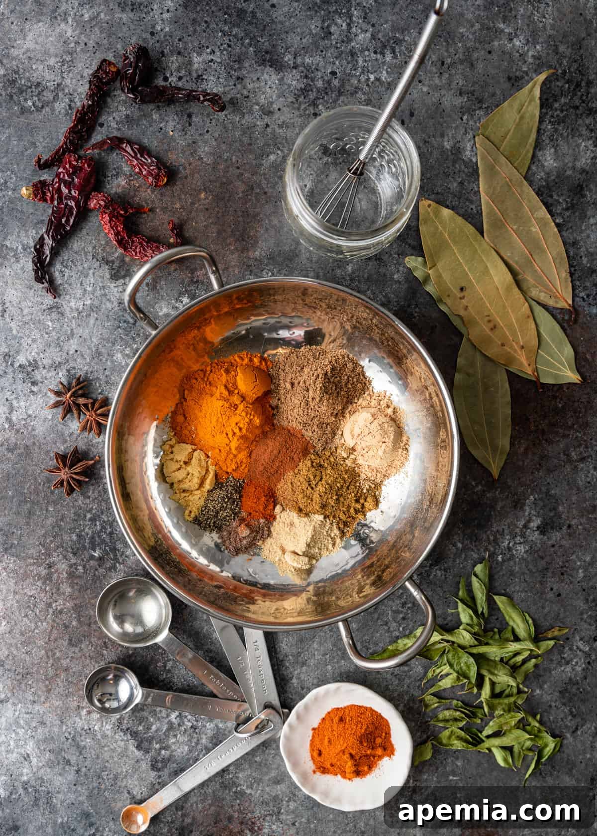 An array of whole and ground spices laid out for making Vindaloo Curry Powder