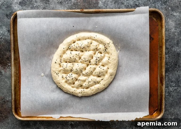 Beloved Turkish Ramadan Pide 20 Ramazan Pidesi dough generously sprinkled with white sesame seeds and black nigella seeds, ready for baking.