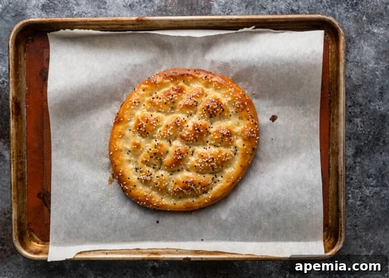 Beloved Turkish Ramadan Pide 21 A freshly baked, golden-brown Ramazan Pidesi, showcasing its beautiful texture, pattern, and toasted seeds.
