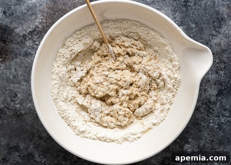Beloved Turkish Ramadan Pide 6 Roughly mixed, shaggy dough in a bowl, indicating the initial stage of combining ingredients for Ramazan Pidesi.