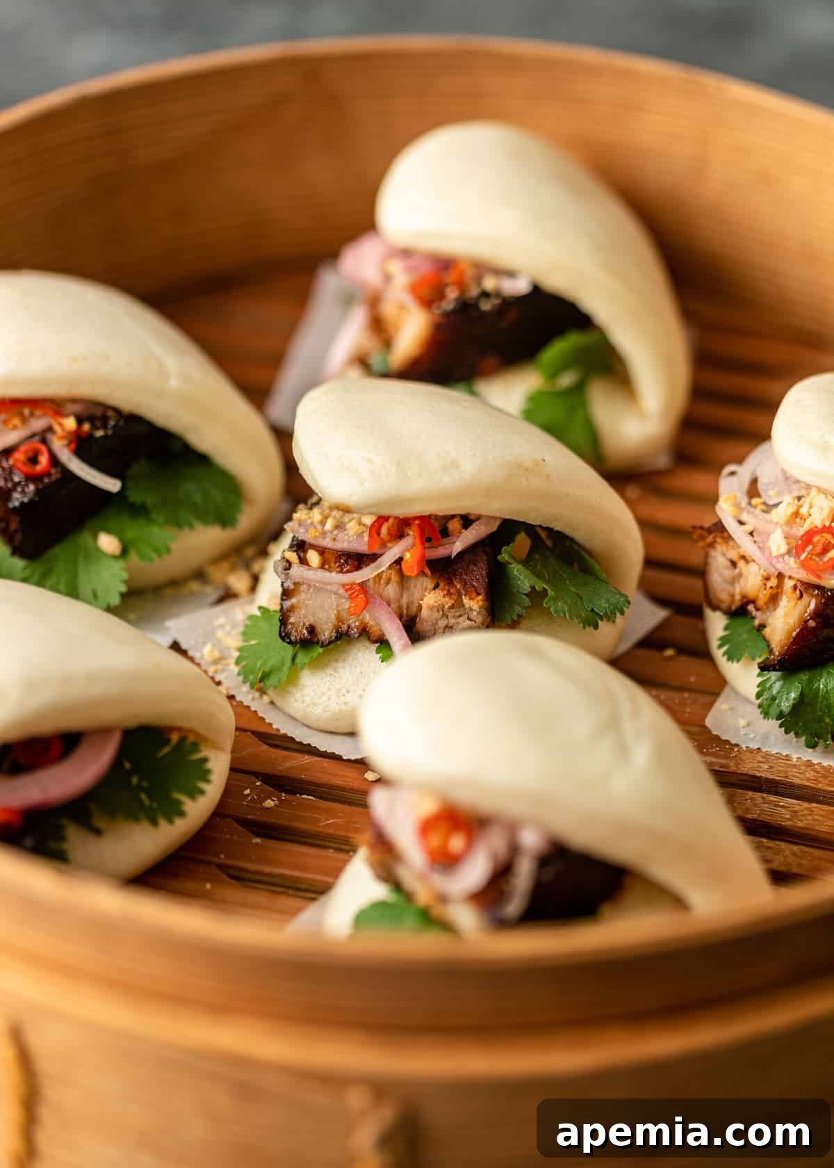 closeup: ready to serve pork belly bun in a wooden steamer
