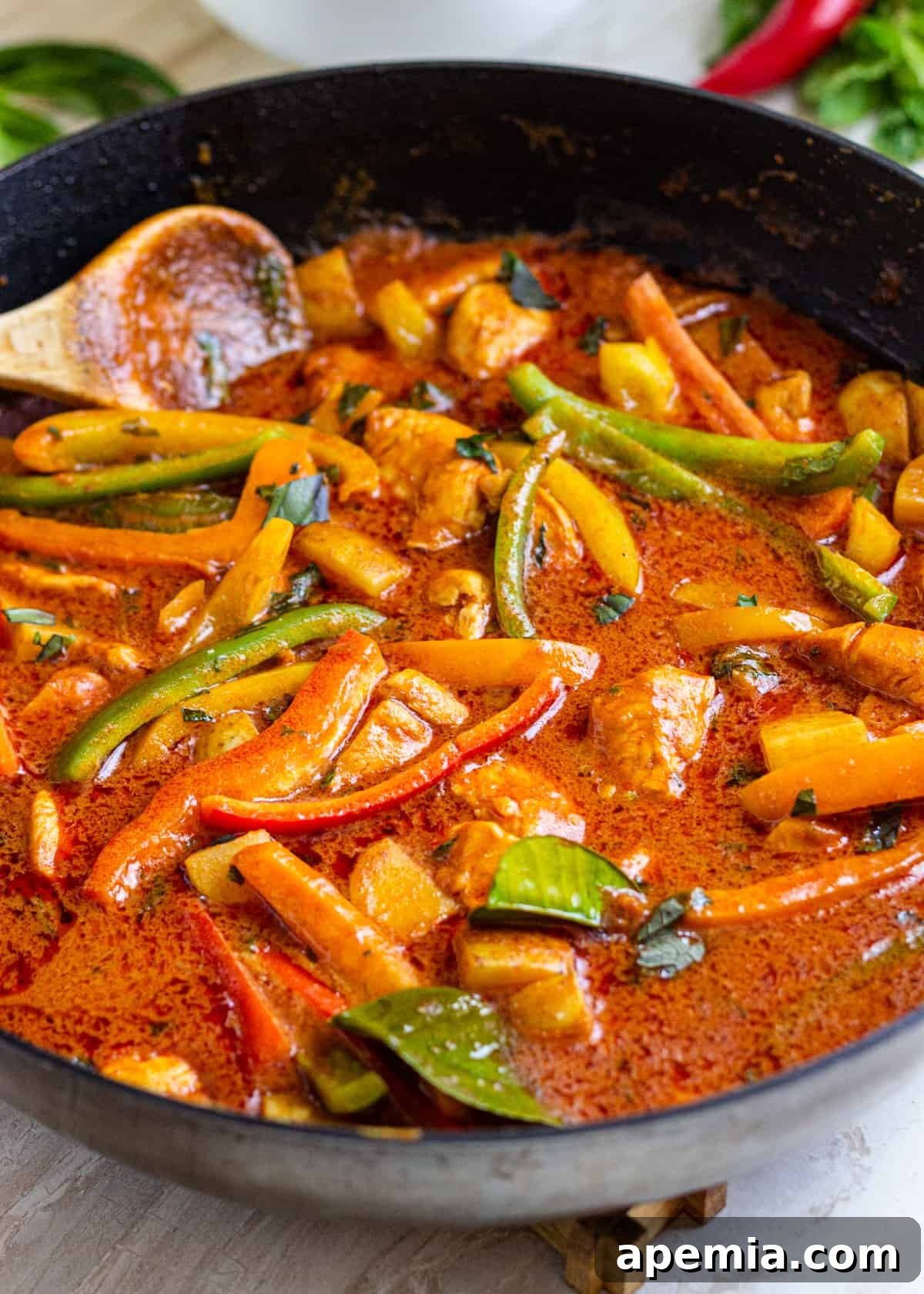 closeup: pan of my red curry recipe with a wooden spoon