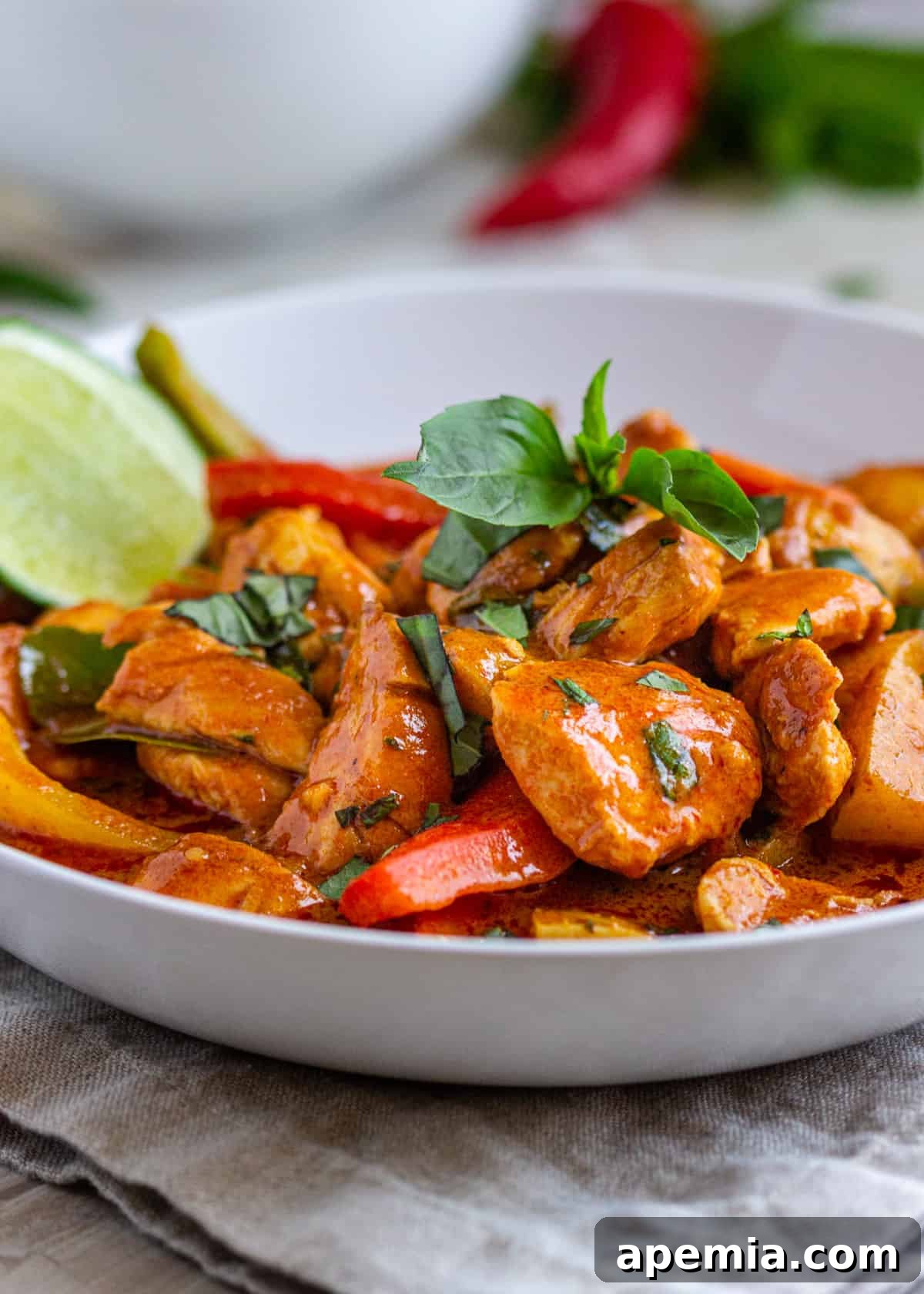 side view: thai red curry chicken in a bowl