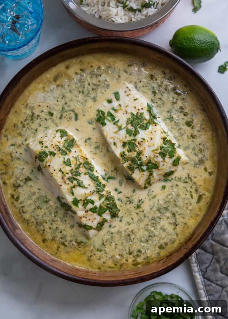 Overhead shot of perfectly baked green curry halibut in a ceramic dish, ready to be served.