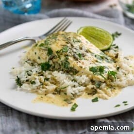 Full plate of Thai Green Curry Halibut served over coconut rice with garnishes.