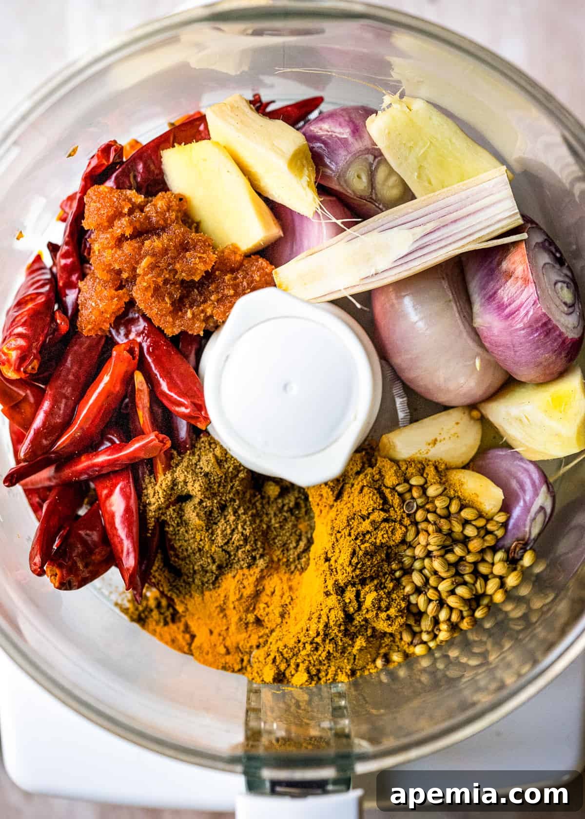 overhead: yellow curry paste ingredients in a food processor before blending