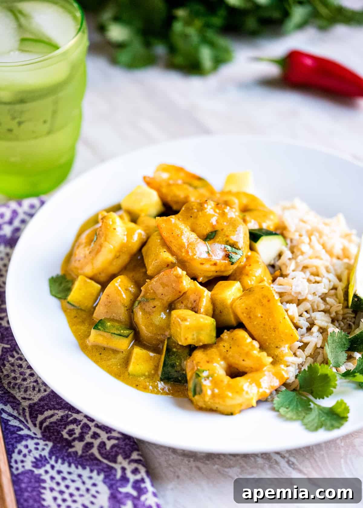 Close-up of a plate piled high with Thai yellow shrimp curry, ready to be eaten.
