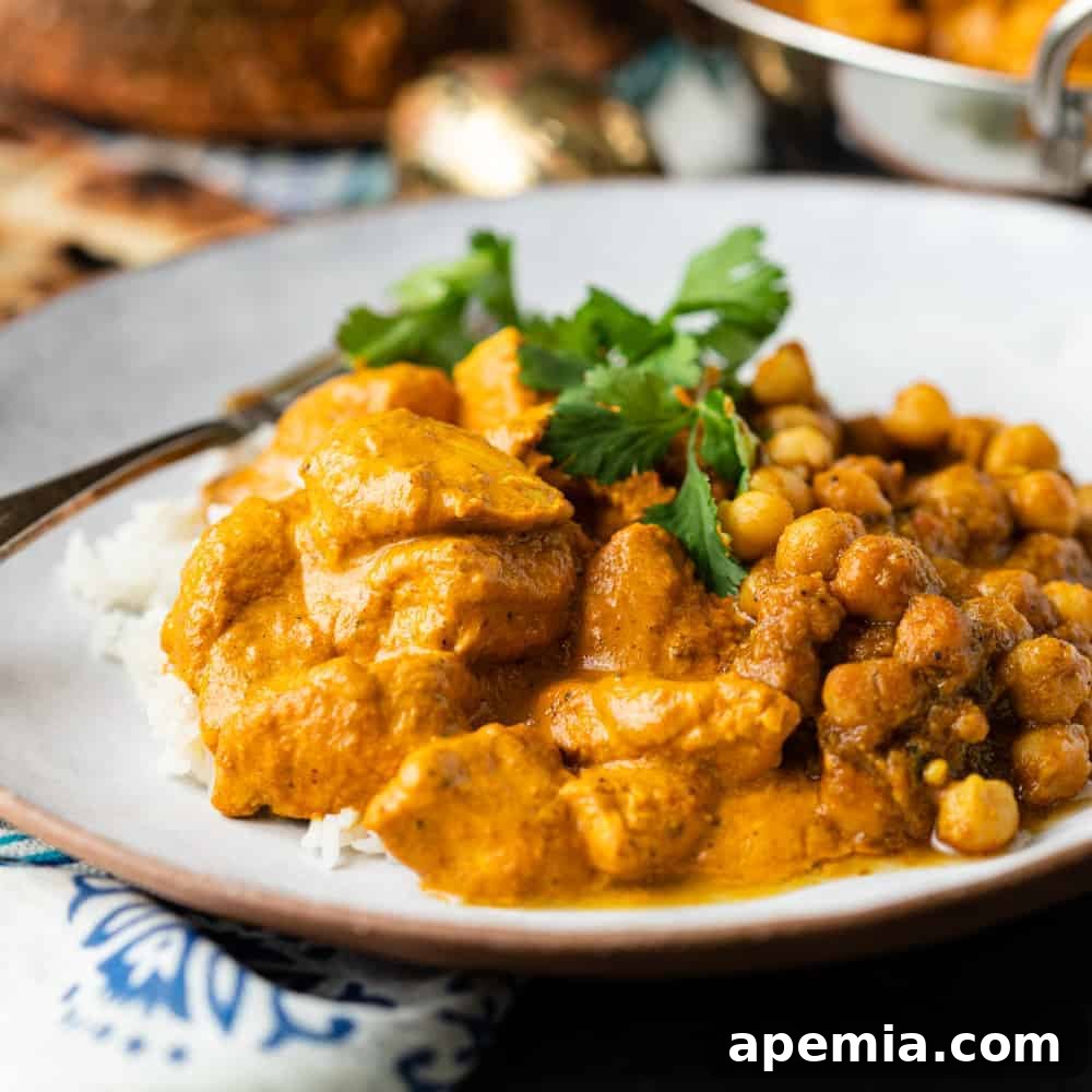 butter chicken with chickpea masala on white plate