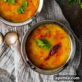 A beautifully presented bowl of creamy Dal Tadka, topped with a swirl of aromatic tadka and garnished with fresh cilantro, capturing the essence of this delightful Indian lentil soup.