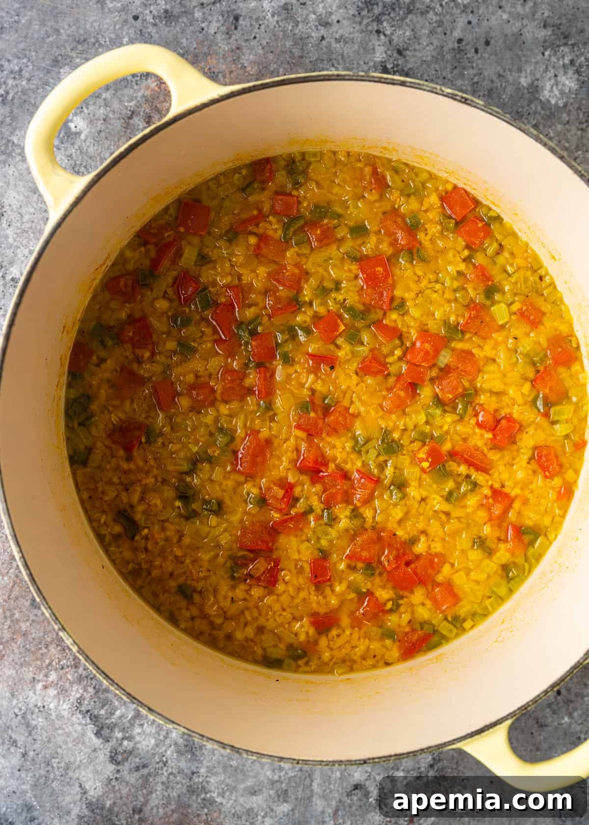 Overhead process shot showing a pot filled with perfectly cooked lentils, having simmered down to a creamy and inviting consistency. The lentils are tender and infused with spices, indicating they are ready for the final addition of tadka.