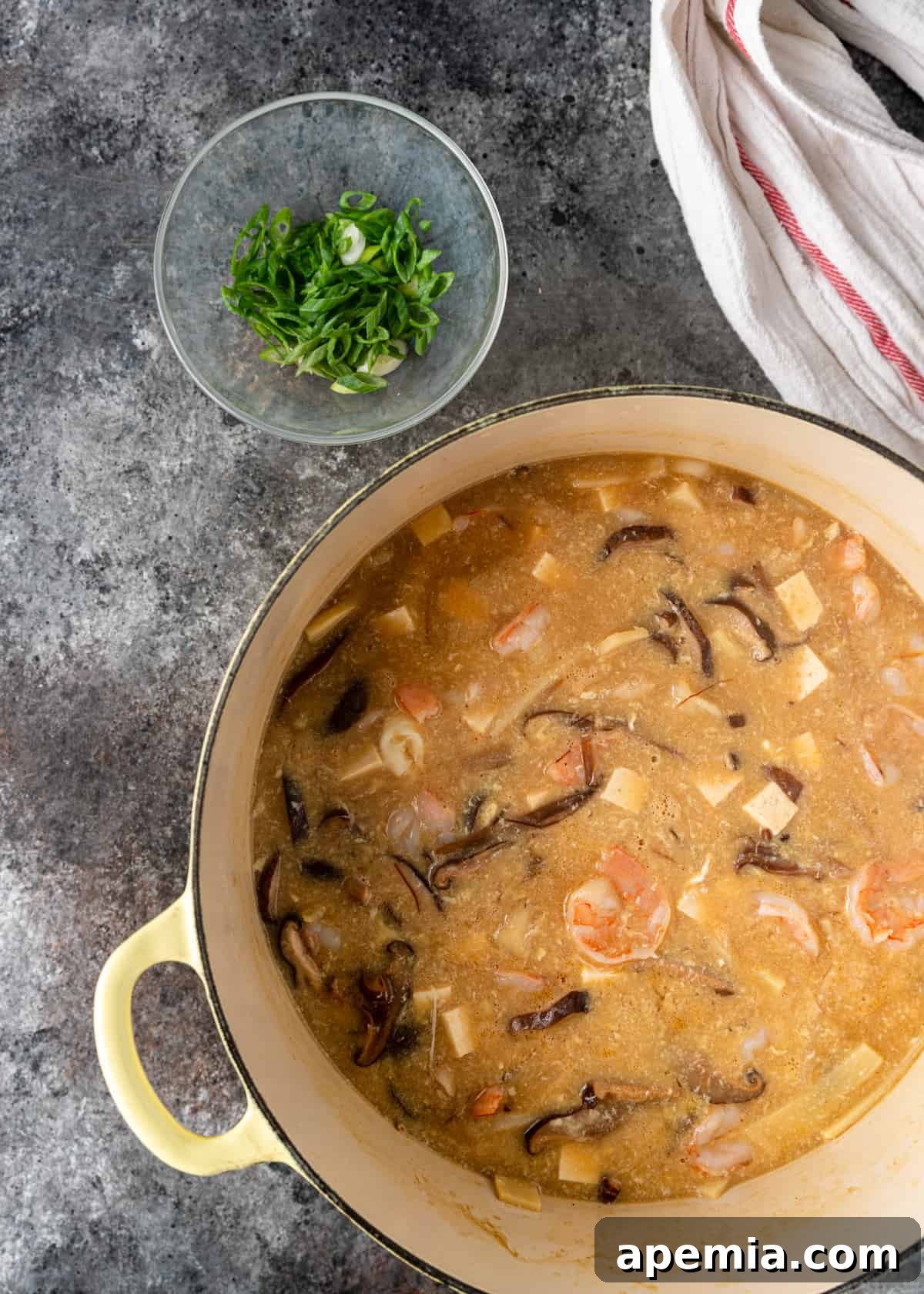 A large stock pot filled with delicious, simmering hot and sour soup, ready for the final touches.