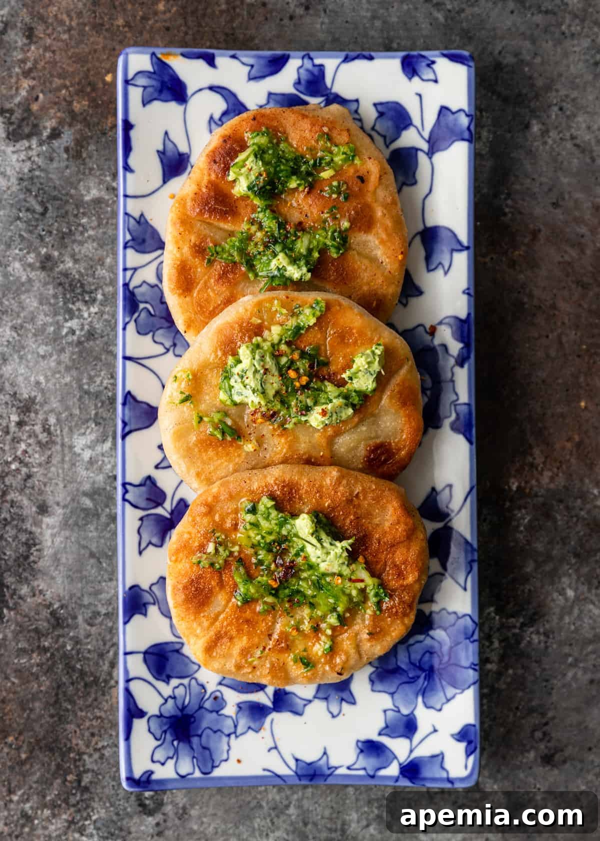 Platter with three freshly fried Chinese Meat Pies, garnished with herbs and chili flakes
