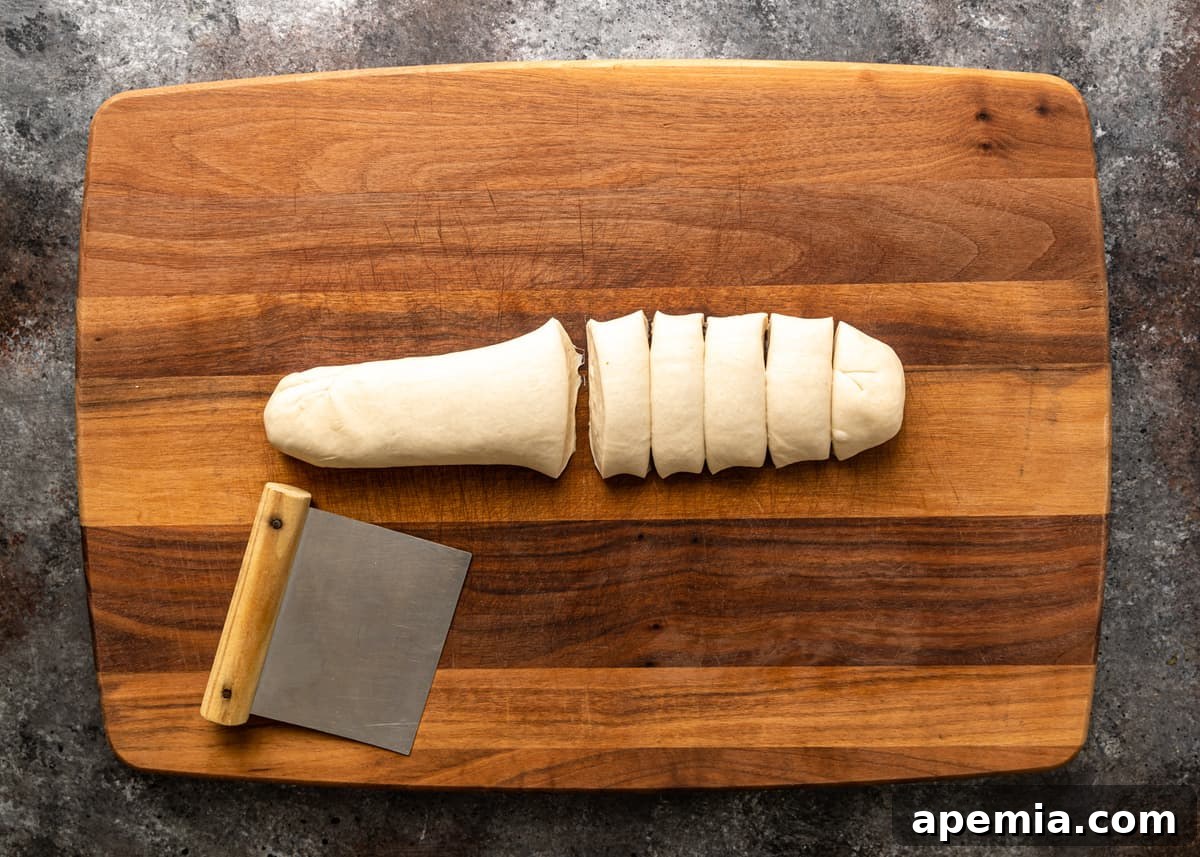 Rolled dough being cut into even pieces for individual Chinese Meat Pies