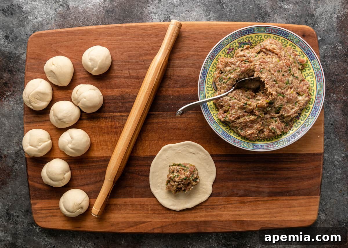 Dough discs being flattened and filled with savory pork mixture