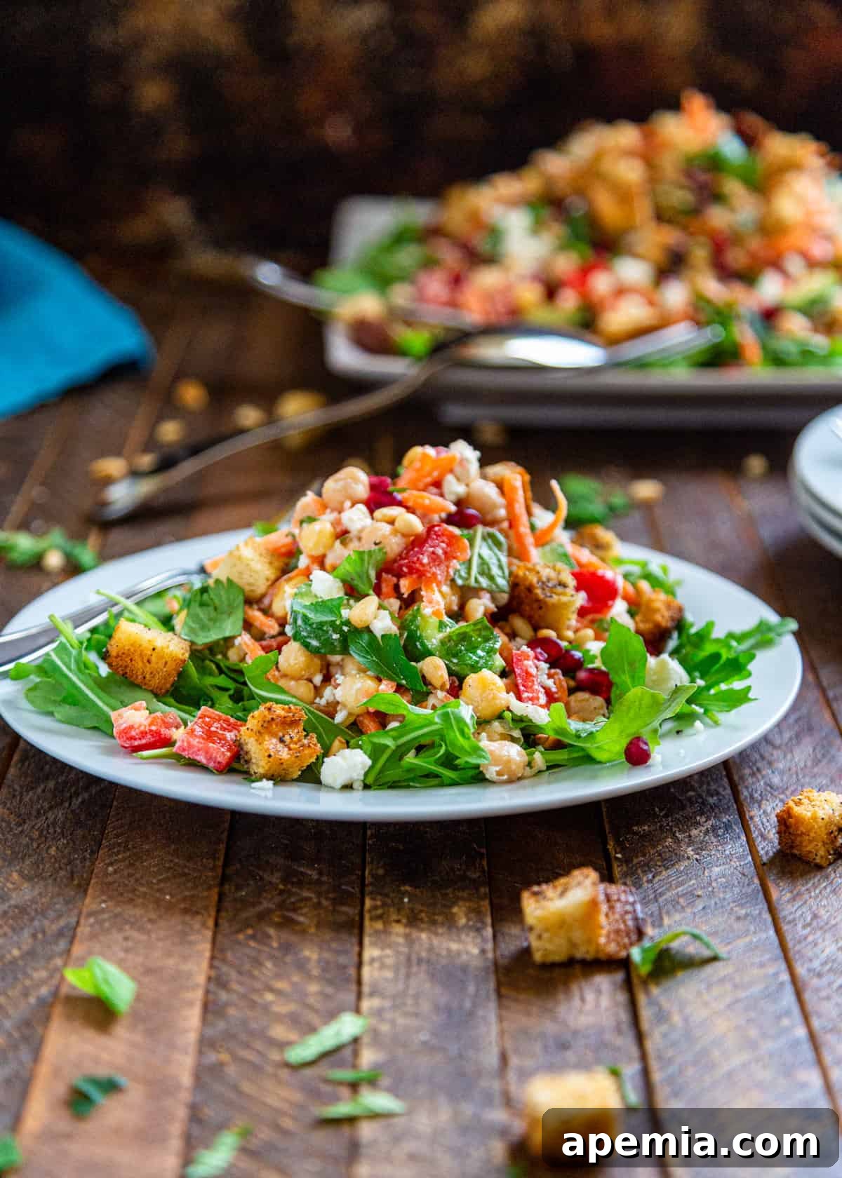 carrots and red bell peppers stacked and cut on top of Mediterranean chickpea salad