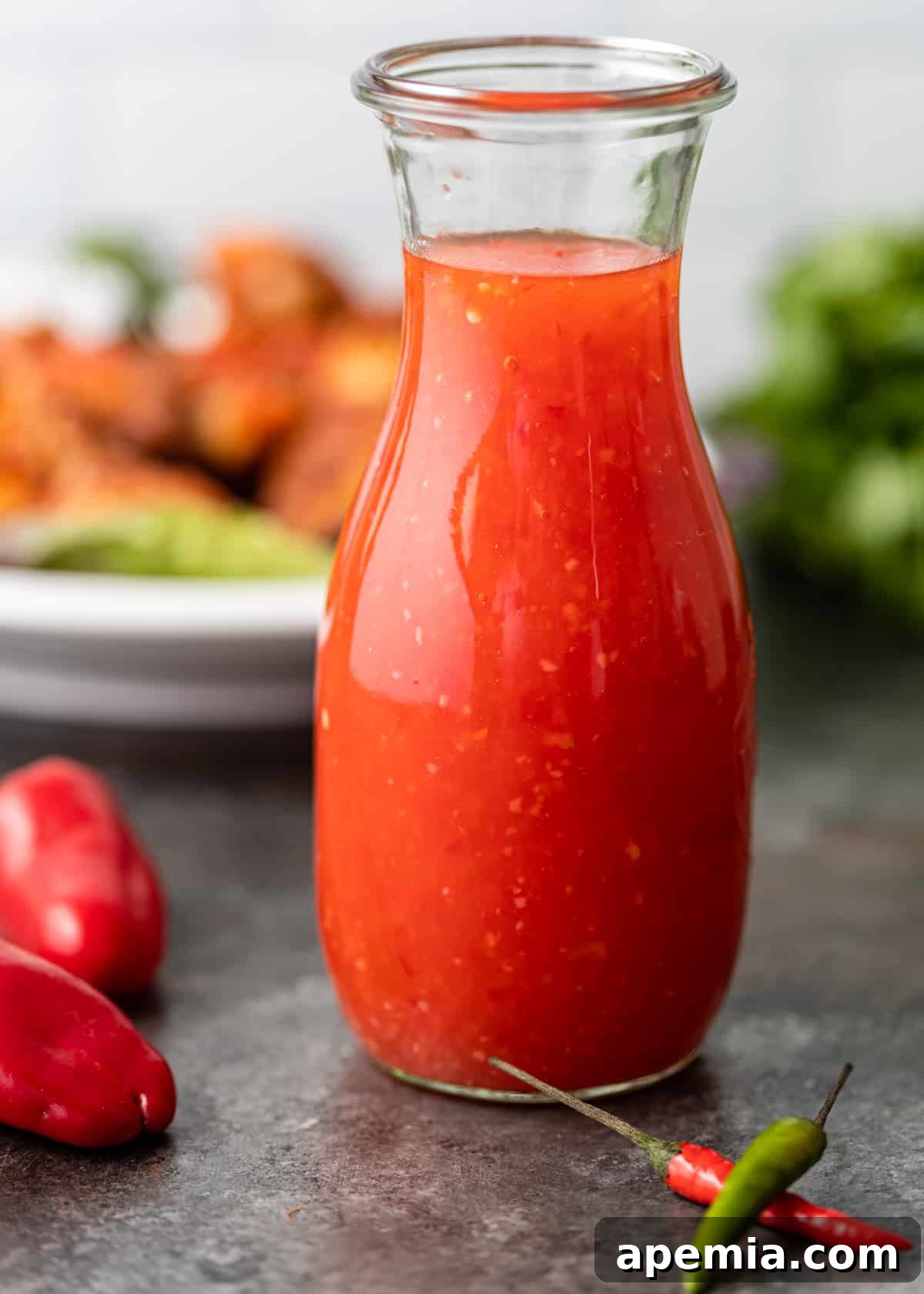 closeup side view: glass jar with sweet chili sauce