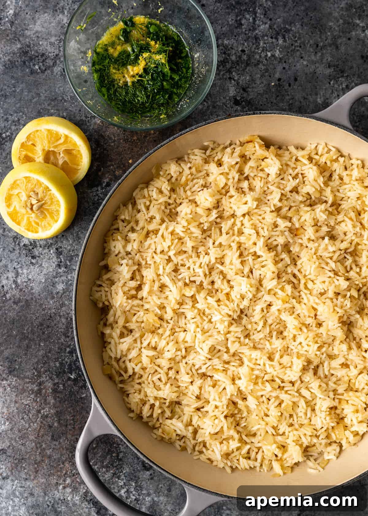 The final process step, where fresh lemon juice, lemon zest, and a vibrant medley of minced fresh herbs are stirred into the cooked Greek lemon rice.