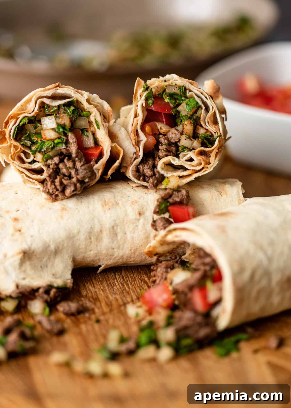 side view: stack of tantuni wrap sandwiches on a cutting board